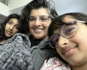 Girl with glasses and woman and teen girl under blankets