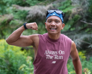 A man runs and flexes his bicep