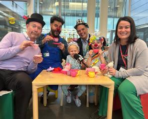 Some adults playing with a kid in a playroom