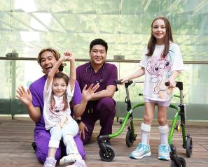 Two adults nurses are having group photos with two children patients