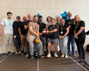 group of clinicians standing in atrium and posing for a photo 