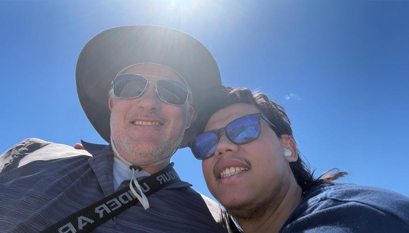An adult with a teen are enjoying the summer with their sunglasses on