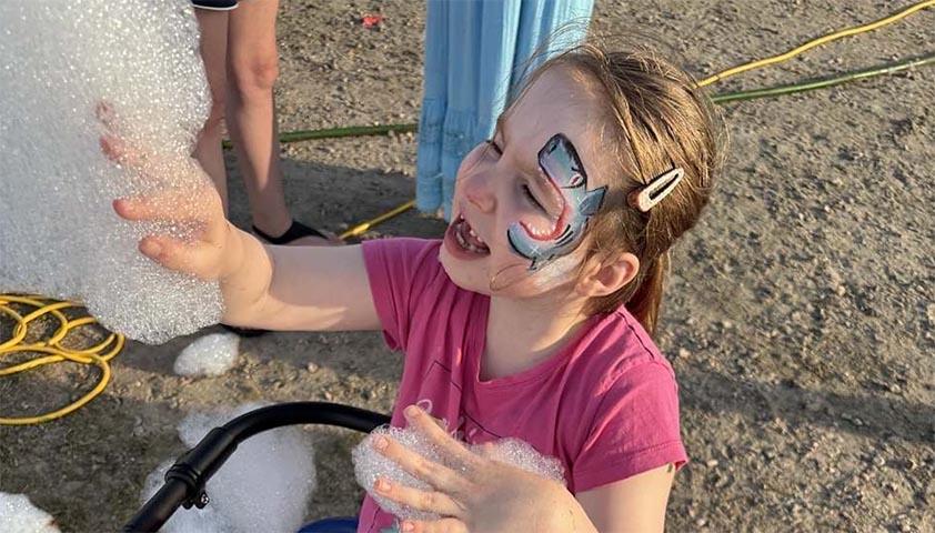 A child is playing with some bubbles