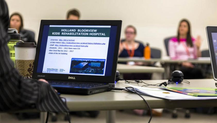 Student with a laptop participating in a discussion