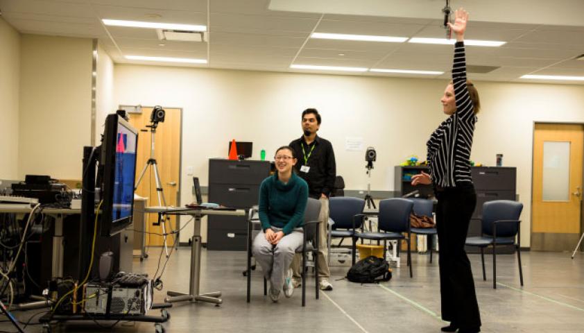 Scientist demonstrating an interactive game to a student and colleague