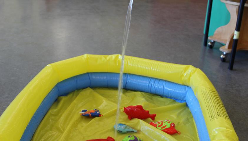 Water being poured into an inflatable kiddie pool. 
