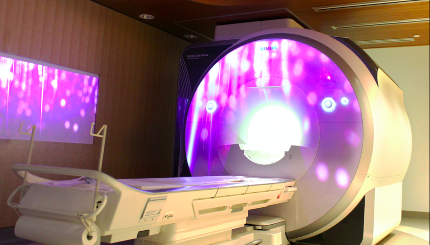 Photo of the MRI with a purple projection on it. 