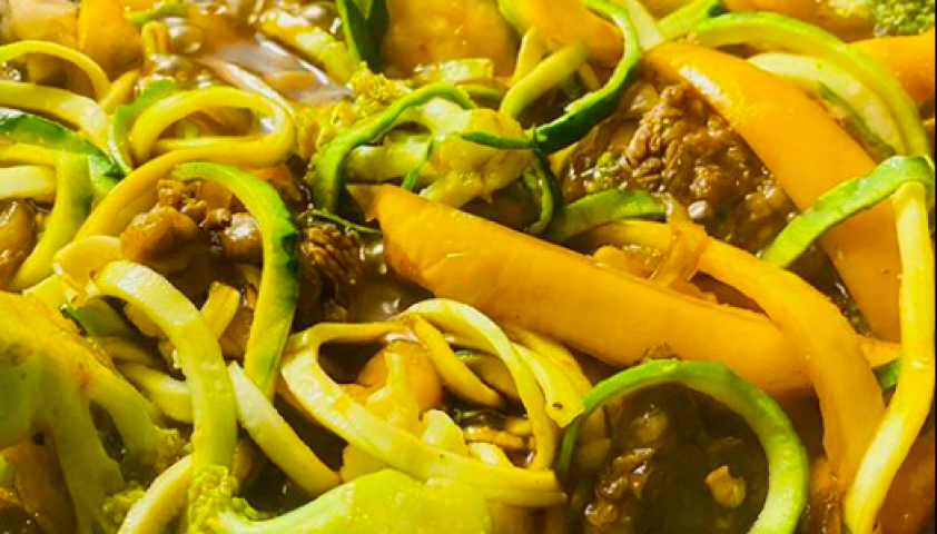 Close-up shot of beef stir fry with broccoli and zucchini and peppers. 