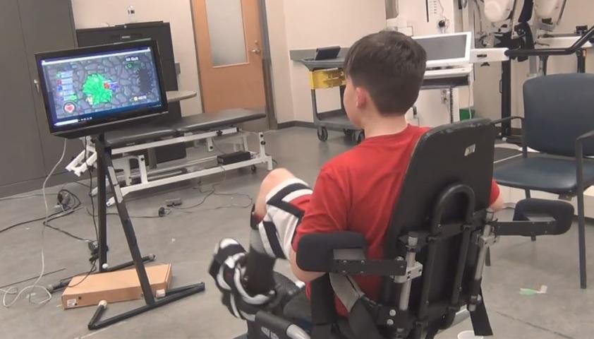 Maddox Miles-Haapala, a research participant with cerebral palsy, plays with the Liberi Exergame