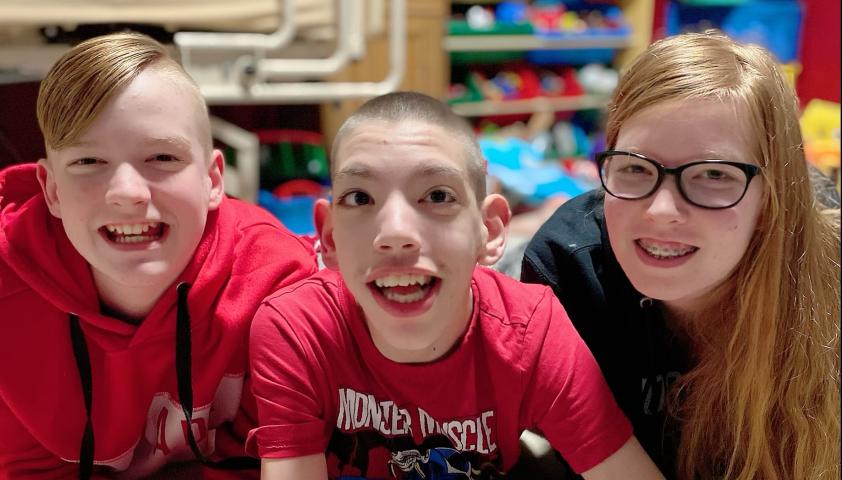 Matthew smiling with his siblings.