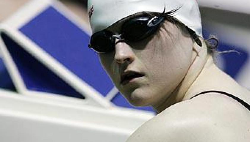 Cynthia posing for the camera during a race, wearing a swim cap. 