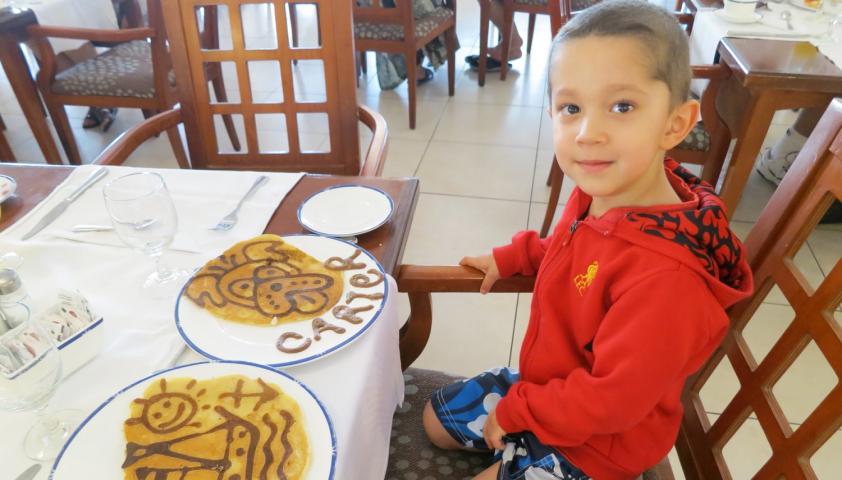 Carter as a young kid sitting with pancakes.