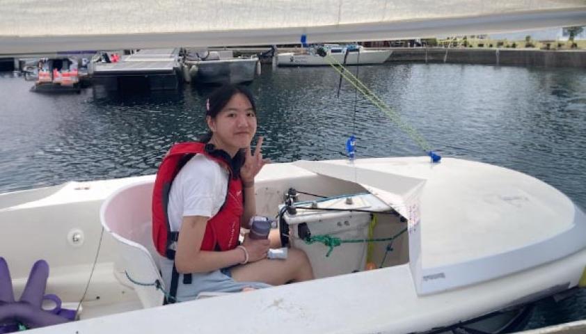 A teenager is riding on a boat