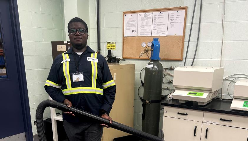 Isaiah standing with a vacuum at work