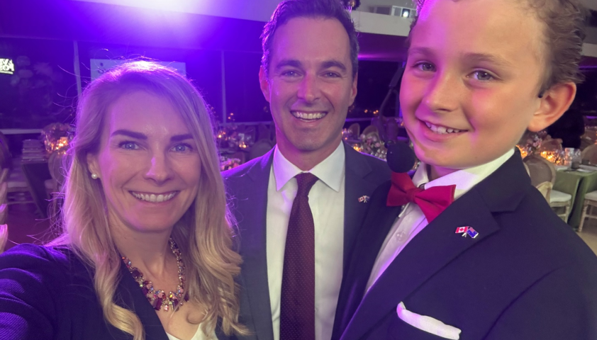 A mom, dad and their son wear formal clothing at a fundraiser event.