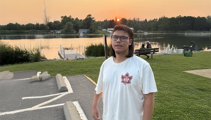 A teenager is standing outdoor to see the sunset