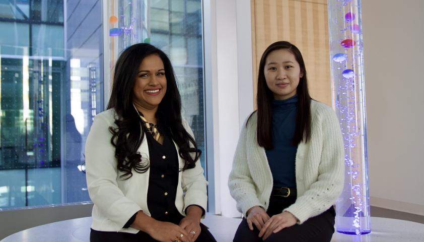 Two adult women sitting in waiting room with a bubble tower in background