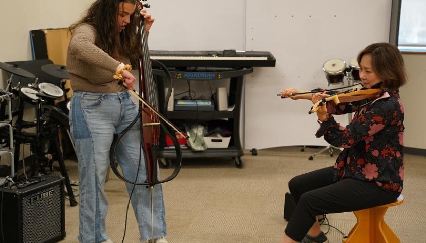 Music therapy intern Reede Parisi plays a duet with Eunice Kang, music therapist.