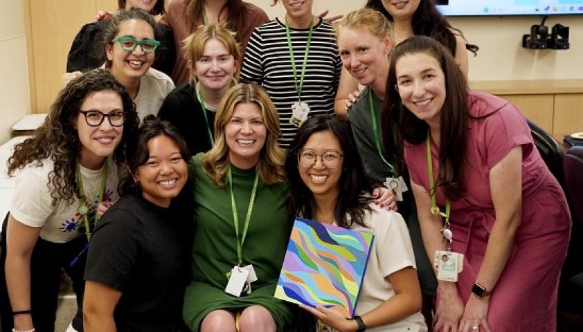 A group of health-care professionals are posing for a team photo