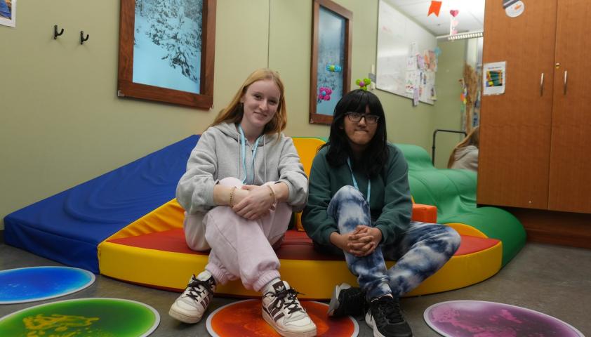 Two volunteers sitting in a playroom