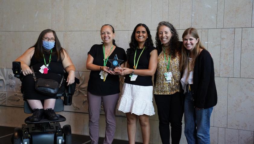 group of health care professionals and researchers hold an award on stage