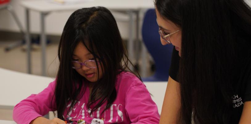A child and an adult playing Bingo at a table