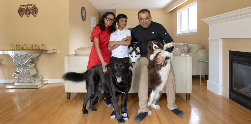 Boy in the middle of woman and man with three dogs