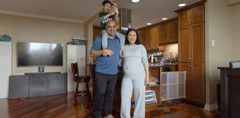Man with young son on shoulders beside woman