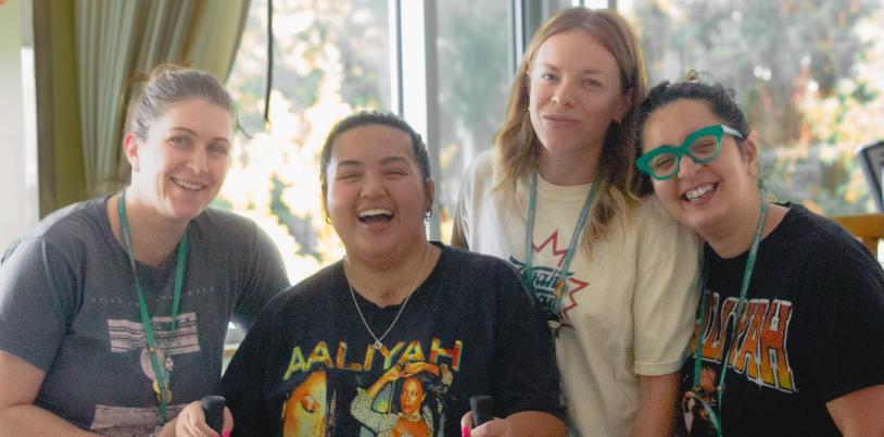 Teen wearing bright shirt and using walker surrounded by three women