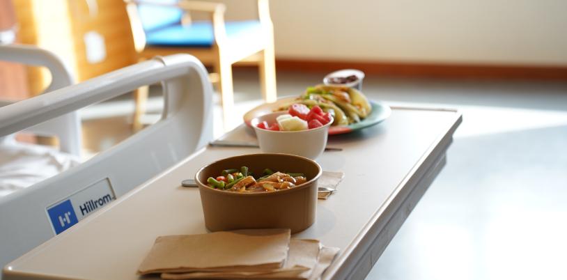 Bowls of food placed on a table in a hospital room.