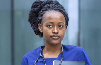 Woman with hair in braids wearing scrubs
