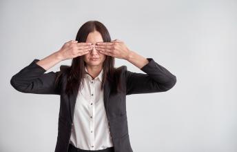 Woman puts hands over eyes