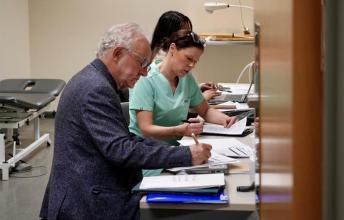 Dr. Peter Rumney reviewing charts with the Brain Injury Rehab team at Holland Bloorview, 2025.