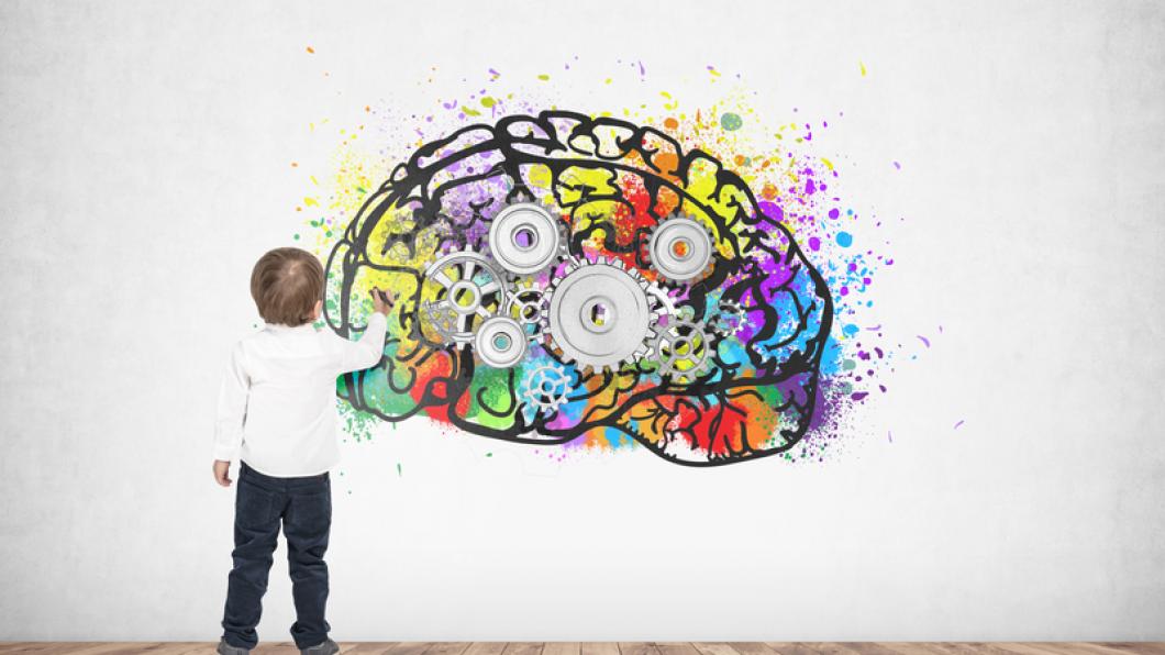 Image of small boy painting a colourful brain