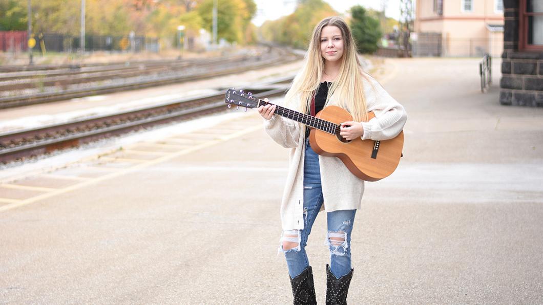 Em Jordan holding her guitar.