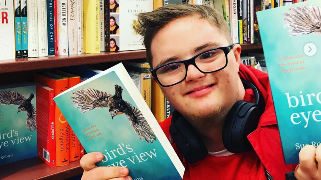 Young man holding book in book store