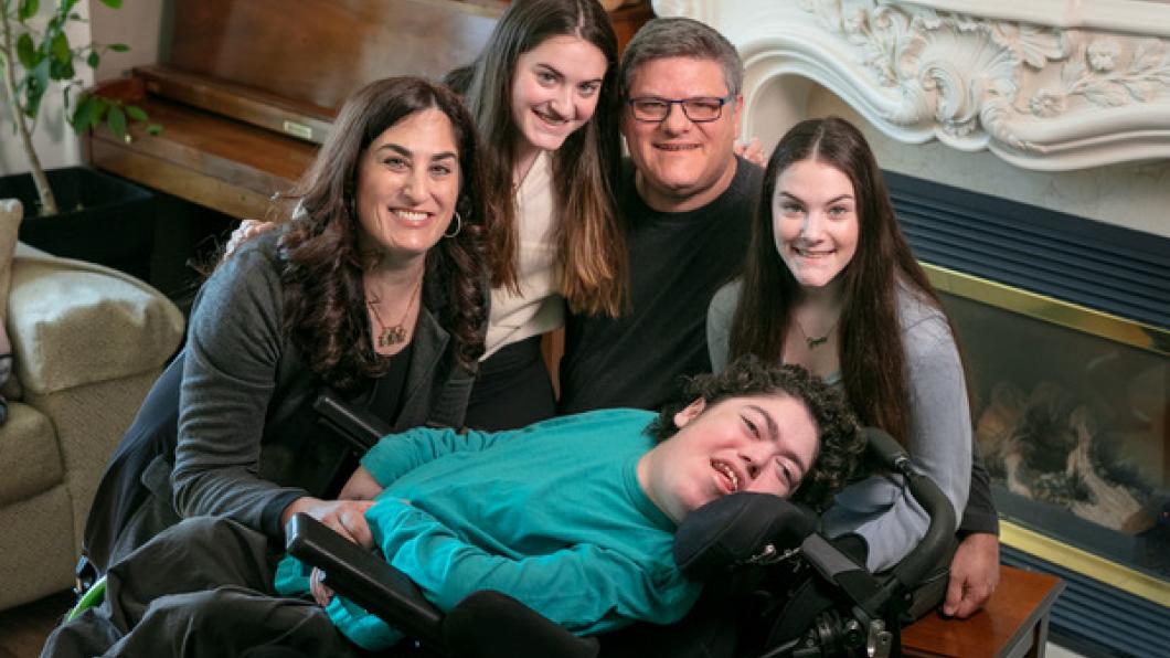 Young man in a wheelchair surrounded by sisters and parents