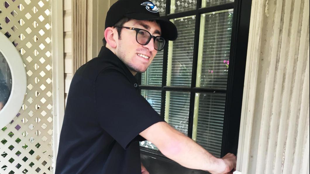 Man using a key to open his front door