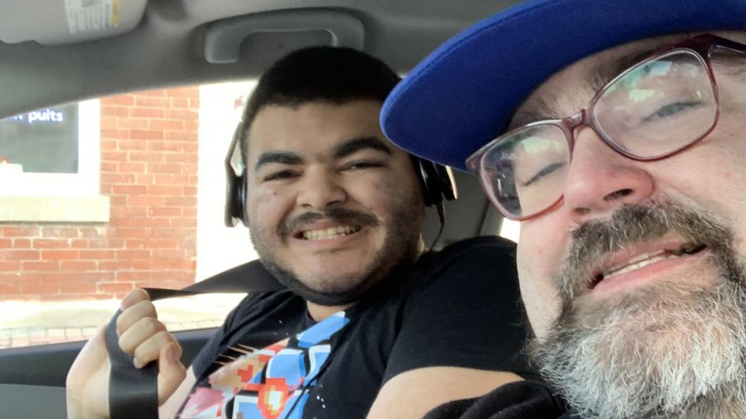 Selfie of father and teen son in car