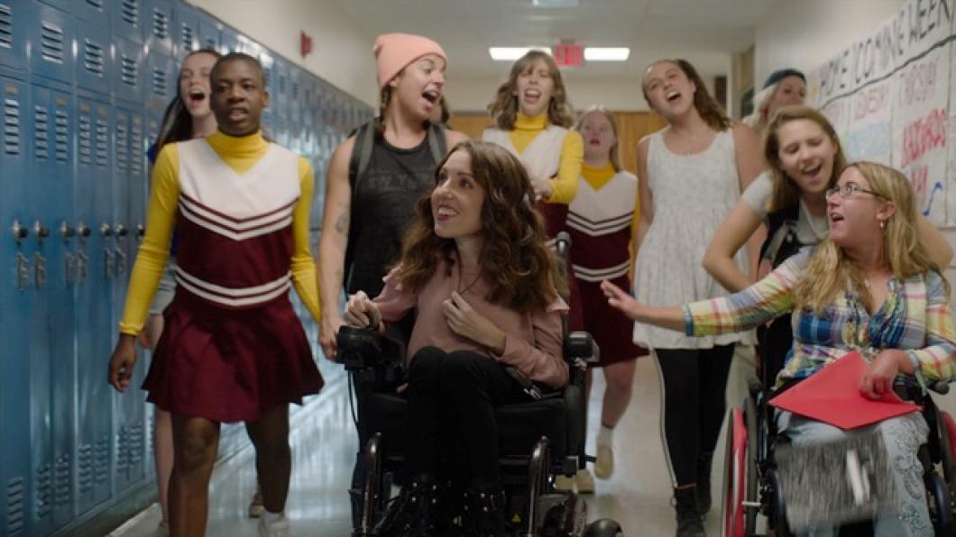 Girls in high school hallway including two in wheelchairs
