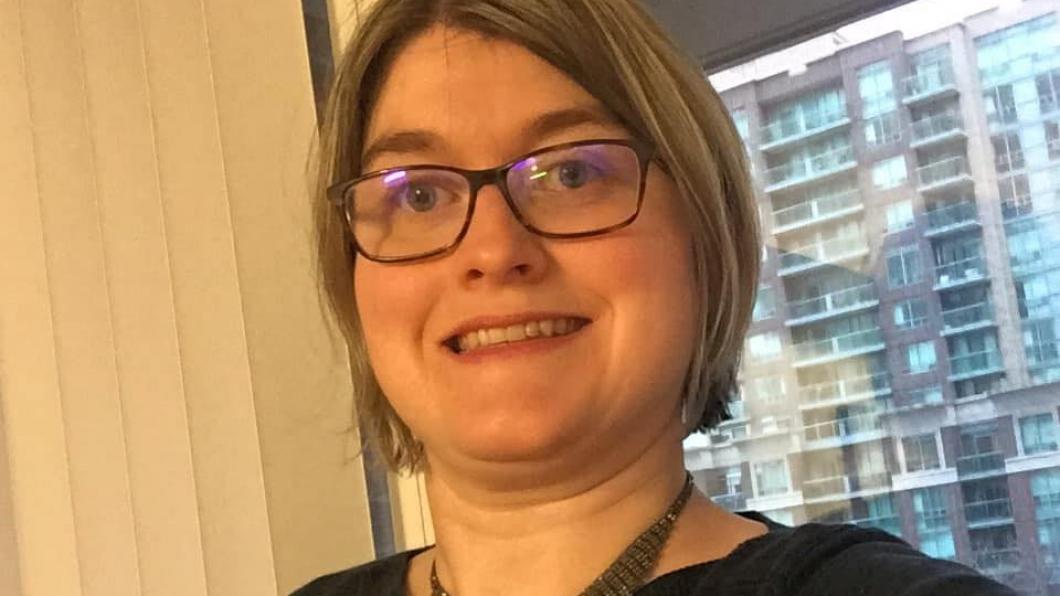 Cynthia smiling at the camera wearing a black shirt.