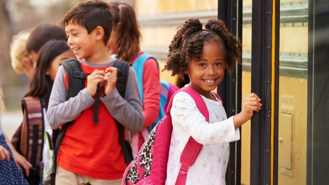 Image of school children getting on yellow bus