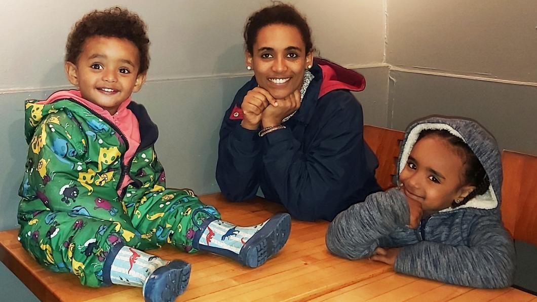 Mother smiling with two young children at table