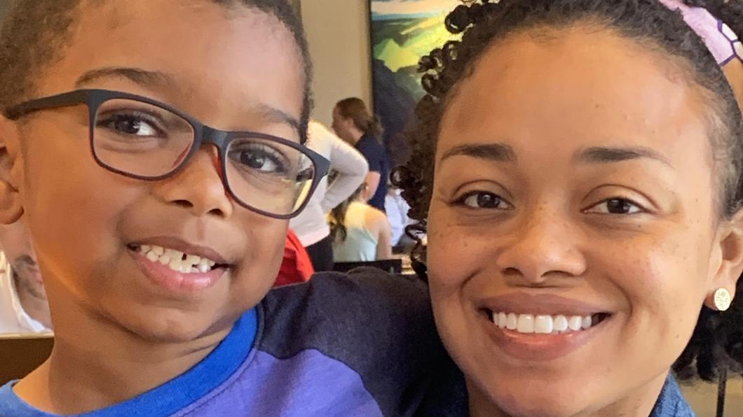 Close up of brown mother and young son with glasses smiling