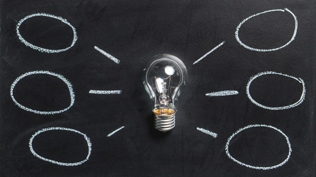 Light bulb in center of chalkboard with circles drawn around it