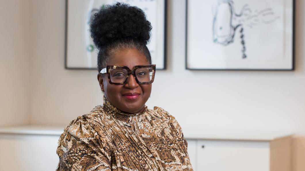 Woman with tortoise shell glasses and hair up on her head smiles