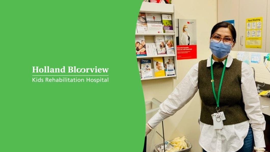Rupinder wearing brown-rimmed glasses, a white shirt and a forest green sweater vest stands next to the Holland Bloorview logo on green background