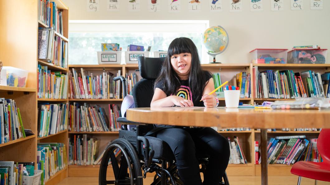 Avery in the classroom sitting at a table.