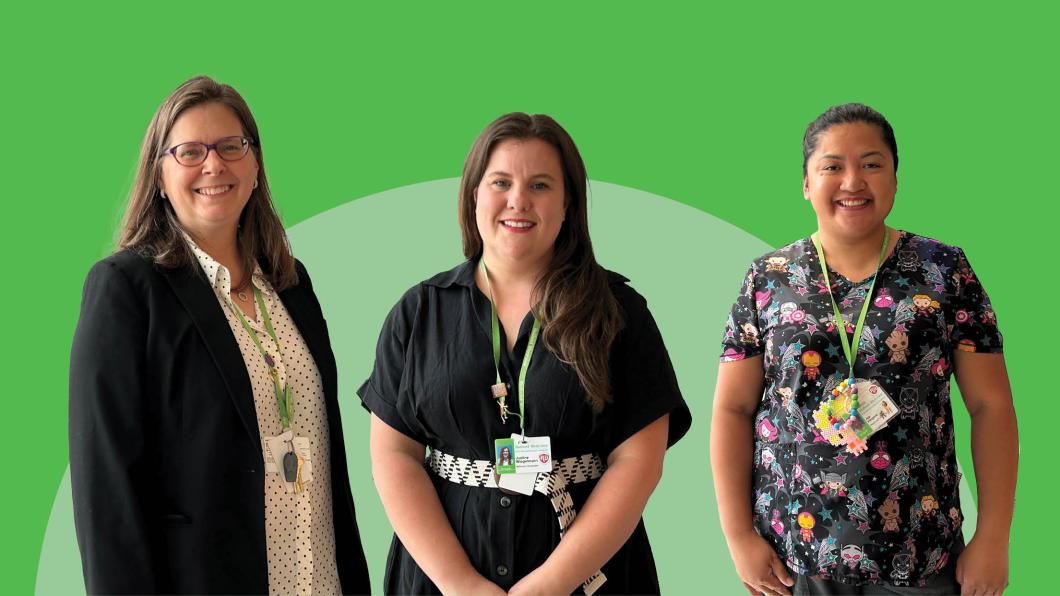 Three people standing smiling in front of a green background.