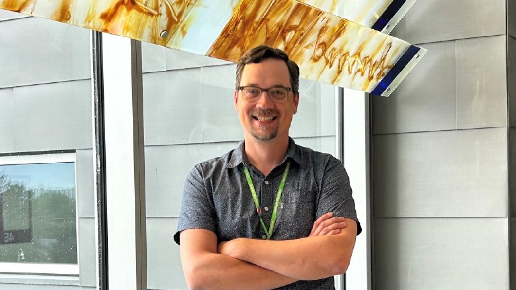 Dr. Jacob Ellegood has been named as the Bloorview Research Institute's new neuroimaging scientist. Image of light-skinned male adult standing by a window with arms crossed, wearing a grey dress shirt.